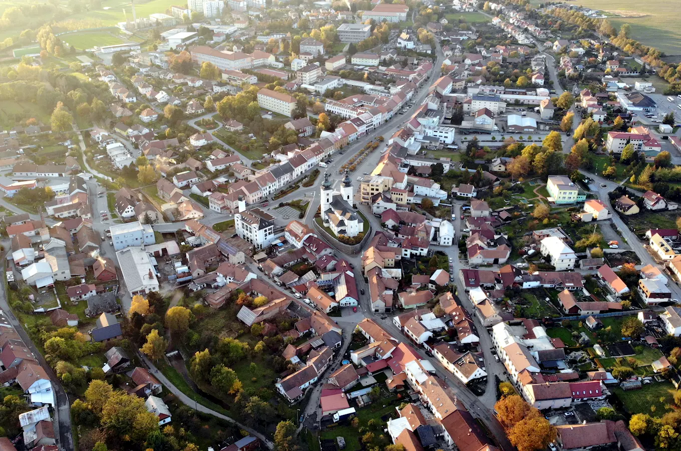 Pohled z letadla na město Bystřice nad Pernštejnem s kostelem a historickými domy.