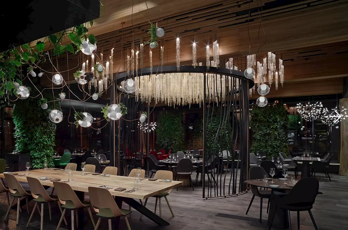 Moderní interiér restaurace s rostlinami a závěsnými lampami