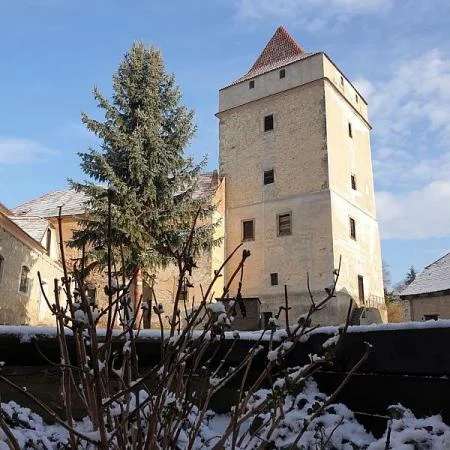 Historická věž tvrze Divice s sněhem na zemi.