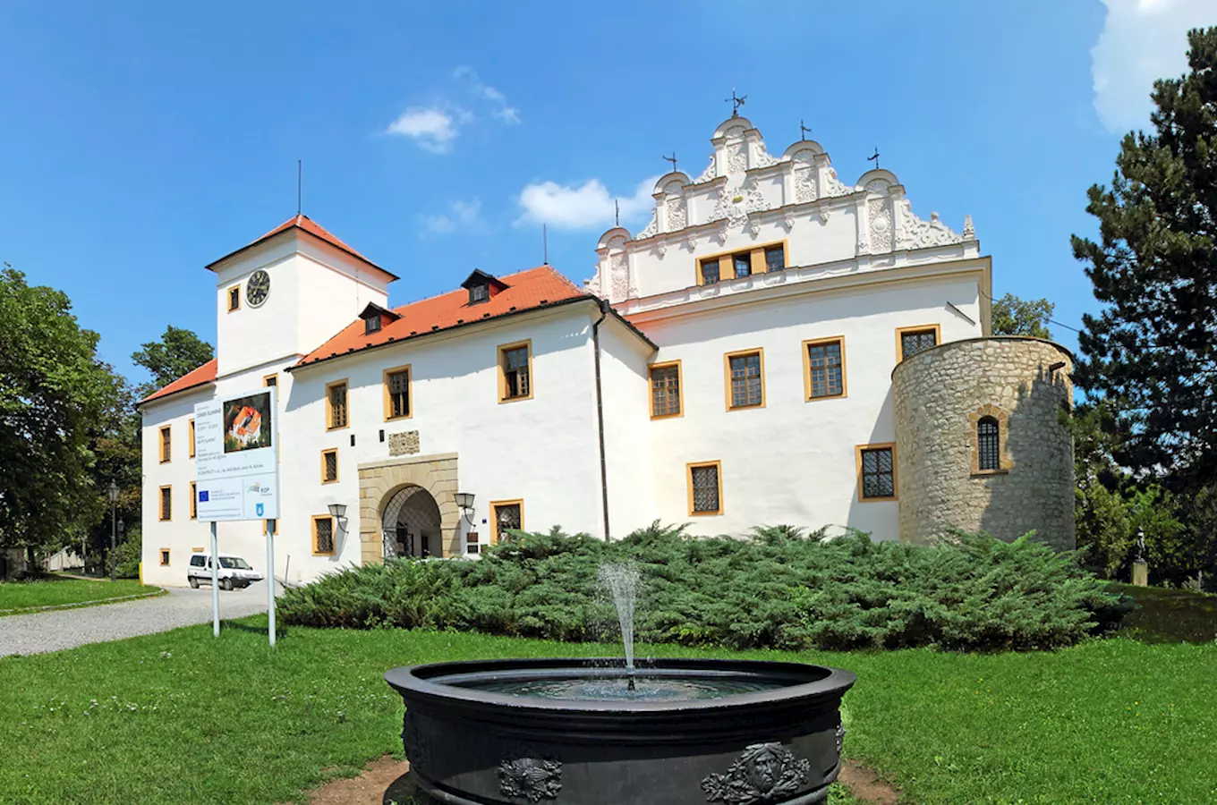 Historický zámek v Blansku s fontánou před budovou.