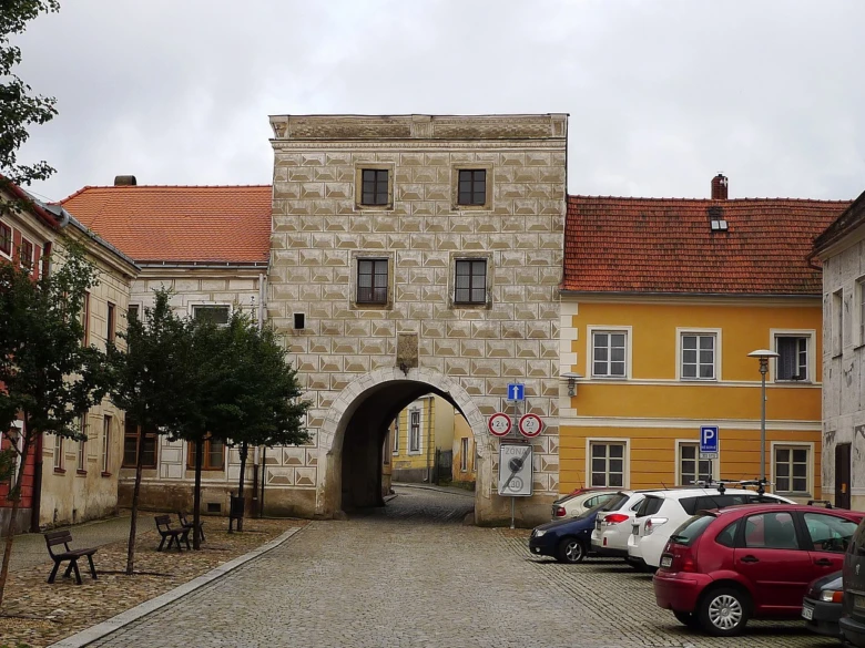 Stará brána ve Slavonicích s parkujícími auty na ulici.