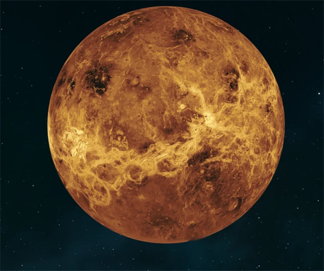 Planeta Venuše s detailním povrchem v oranžovo-hnědých barvách na pozadí hvězdné oblohy.