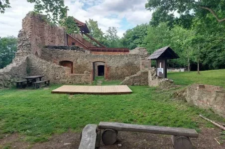 Ruiny historického hradu s dřevěnou scénou v zeleném parku ve Zlínském kraji.