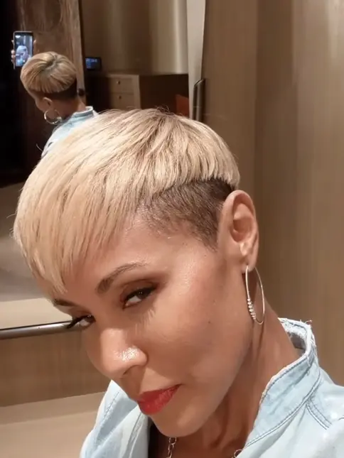 Žena s krátkým blond účesem v kadeřnickém salónu.