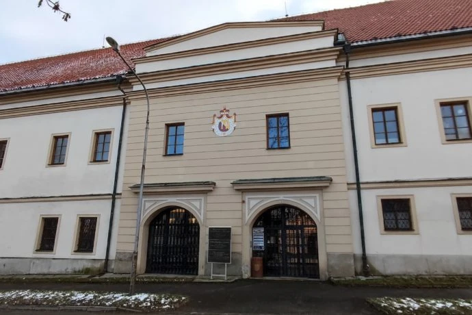 Historická budova v Kyjově s bránami a erbovým znakem.