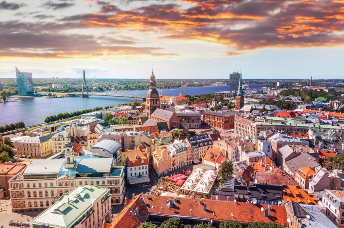Panoramický pohled na Rigu s řekou Dáuvou při západu slunce.