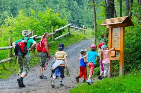 Skupina turistů na stezce v Bílých Beskydách u informačního panelu.