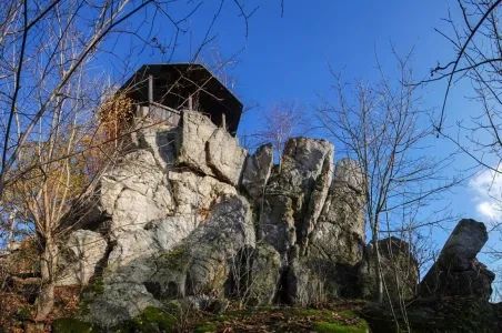 Dřevěná rozhledna na skalním útvaru v přírodě.