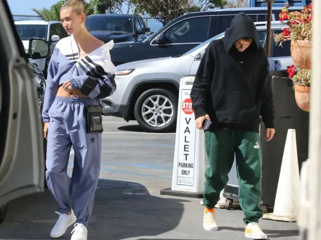 Hailey Bieber chodí venku v modrém sportovním oblečení.