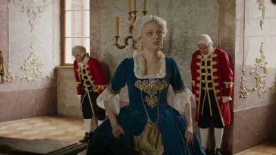 Portrét Marii Antonie v historickém kostýmu s dvorníky.