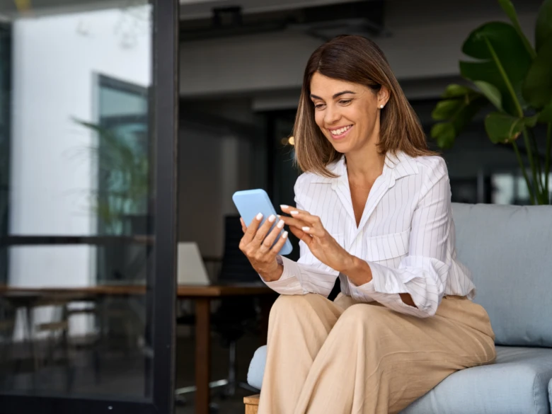 Žena se usmívá při používání mobilního bankovního účtu.