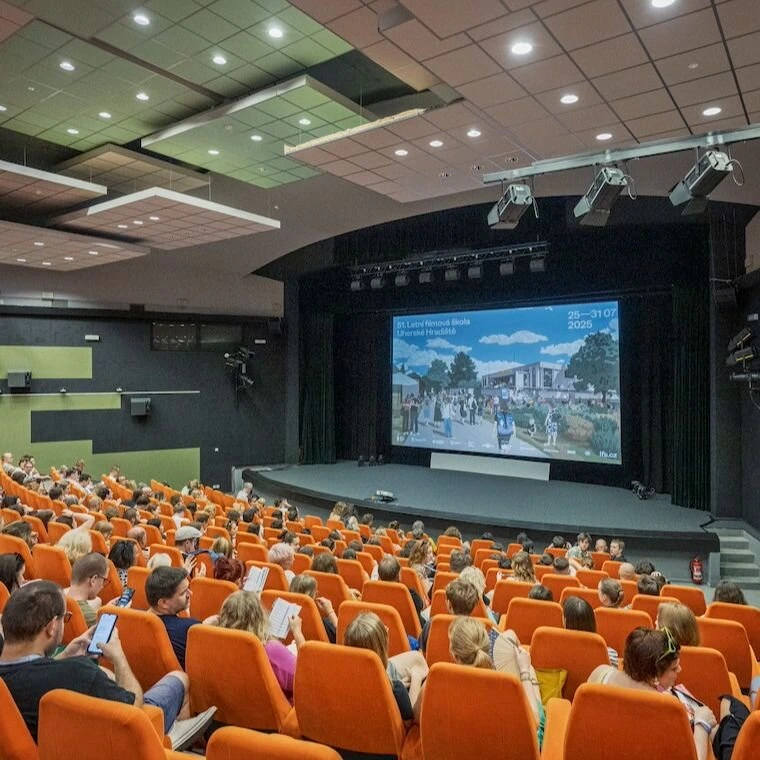 Divadlo plné lidí sledujících prezentaci o kulturní akci ve Zlínském kraji.