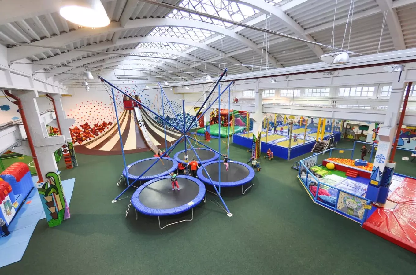 Vnitřní hřiště pro děti s trampolíny a barevnými prvky.