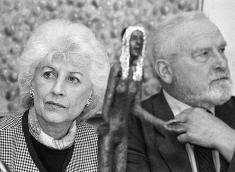 Olga Havlová sedící vedle sochy v galerii.