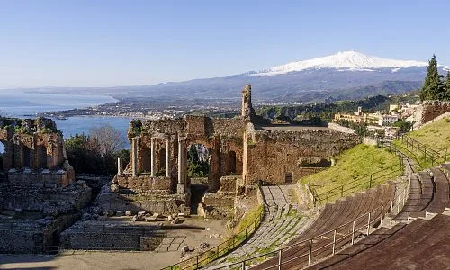 Starověké řecké divadlo v Taormině s sopkou Etna na Sicílii.