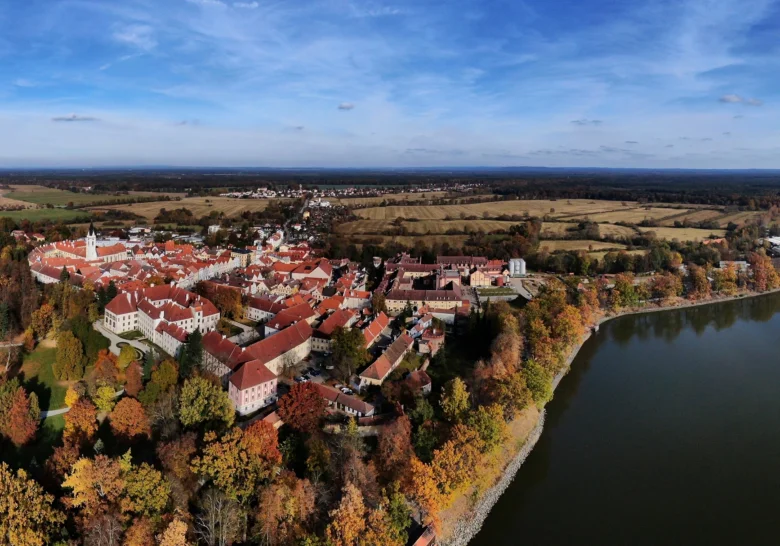 Vzdušný pohled na město Třeboň s jezerem v podzimní krajině.
