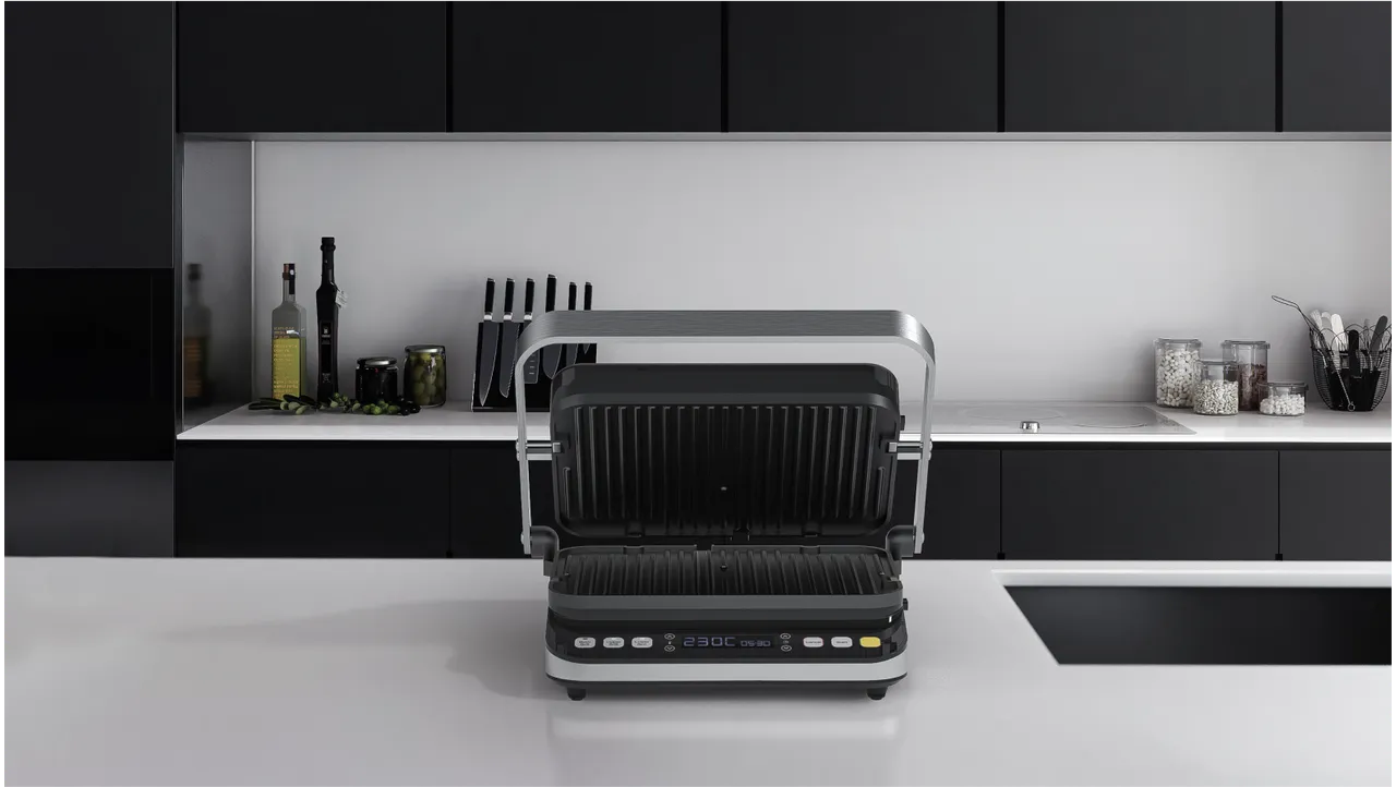 Moderní kontaktní elektrický gril na kuchyňské desce.