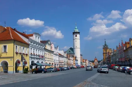 Historické náměstí v Domažlicích s věží na pozadí.
