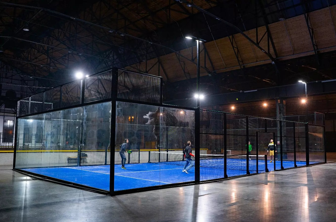 Vnitřní dvorec na padel s hráči v akci.