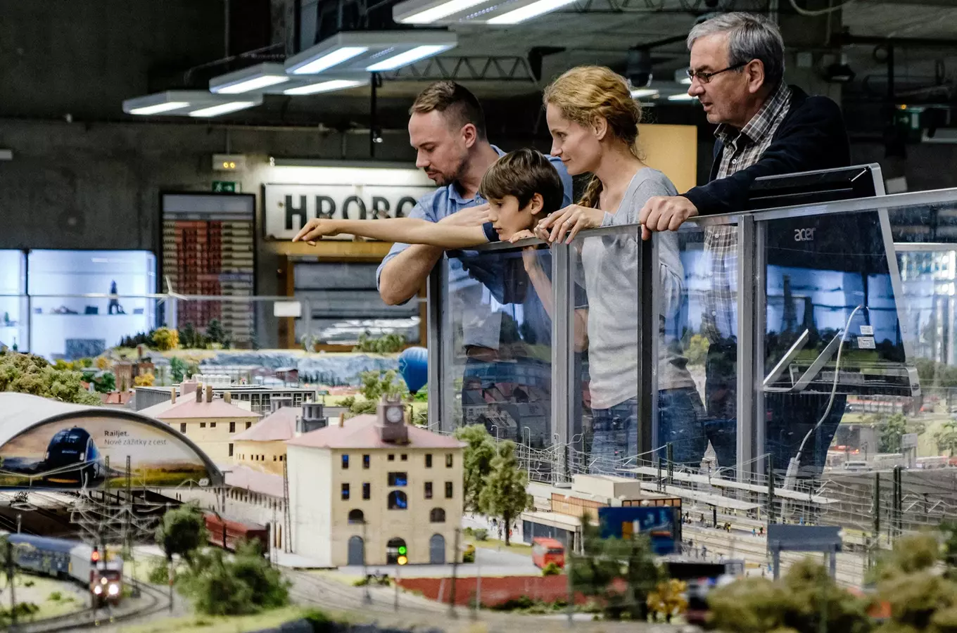 Rodina se podívá na výstavní modelovou železnici v muzeu.