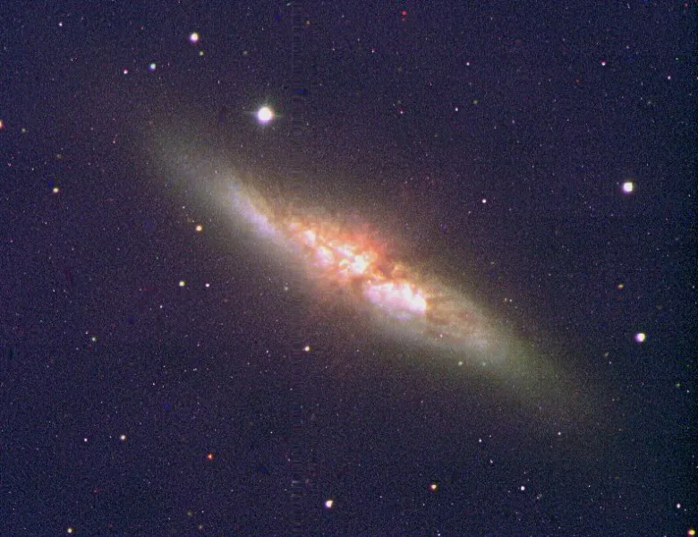 Jasná spirální galaxie s hvězdami na tmavém vesmírném pozadí.