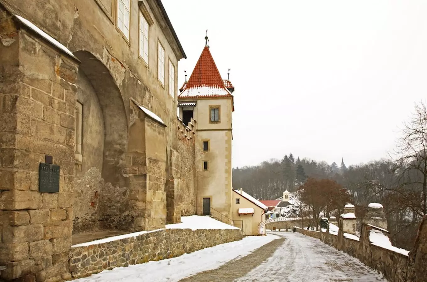 Zimní pohled na hrad Křivoklát s sněhem a věží.