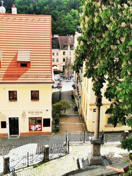 Pohled na náměstí v Loketi s fontánou a historickými domy.