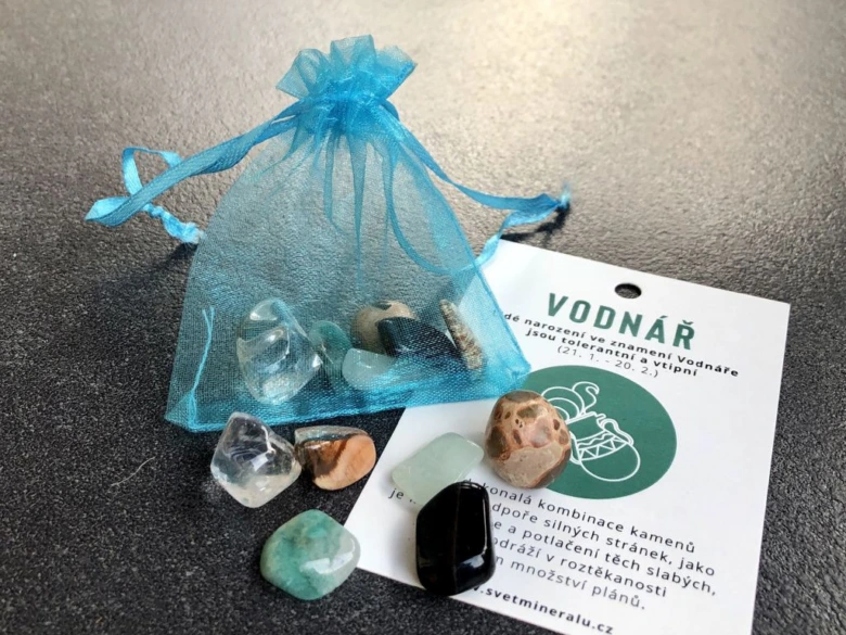 Modrý sáček se kameny vedle karty znamení Vodnář.
