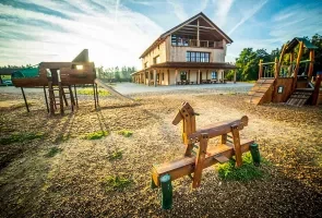 Hřiště s dřevěnou hrou a budovou na Vysočině