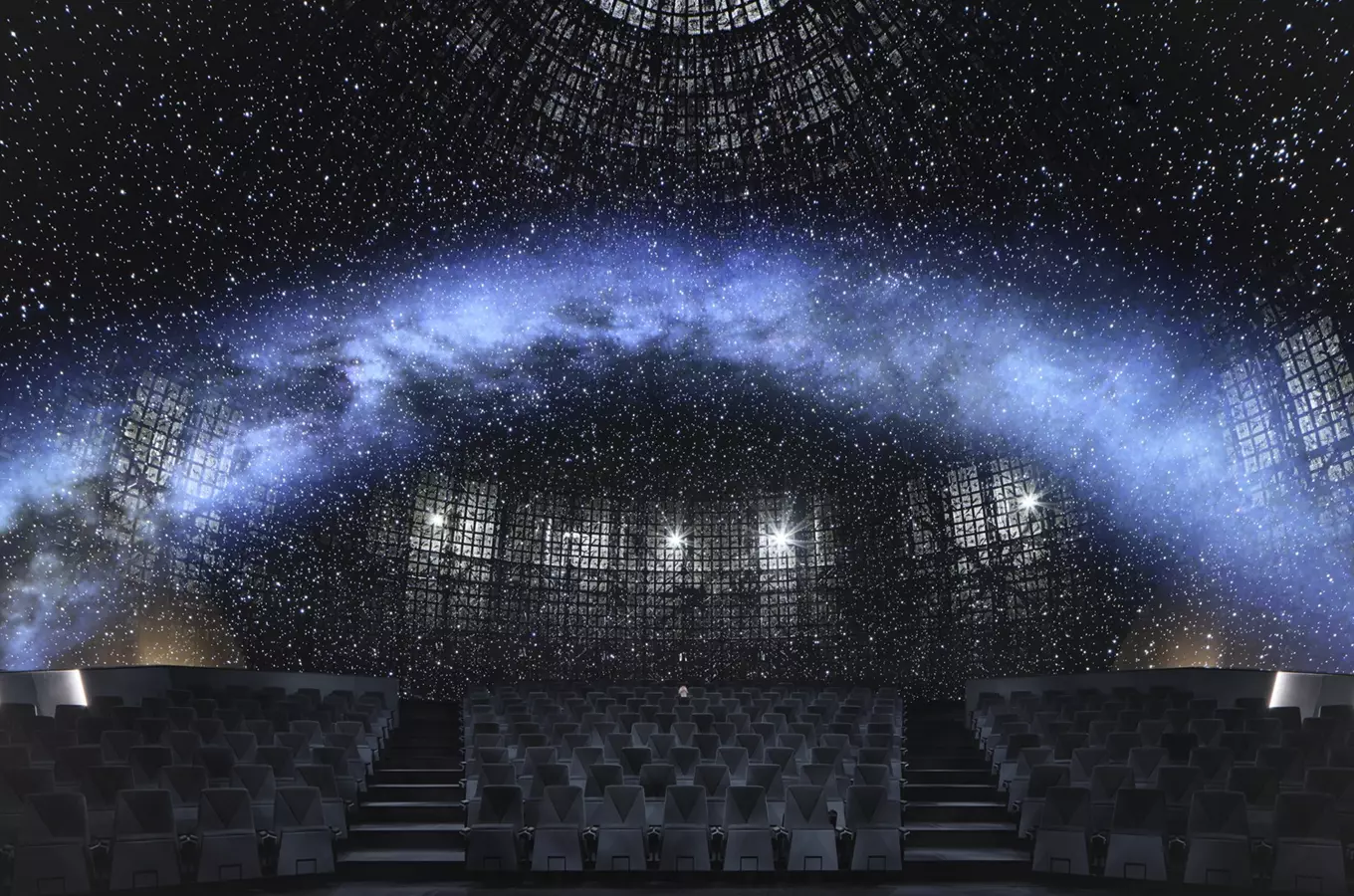 Vnitřek planetária s projekcí hvězdné oblohy na kupoli.