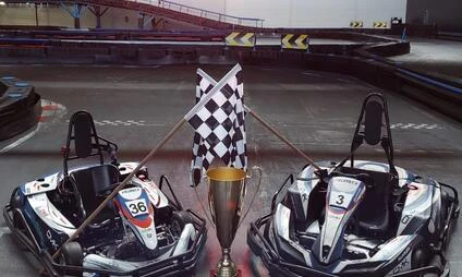 Dvě motokáry s trofejí na vnitřním dráze pro karting.
