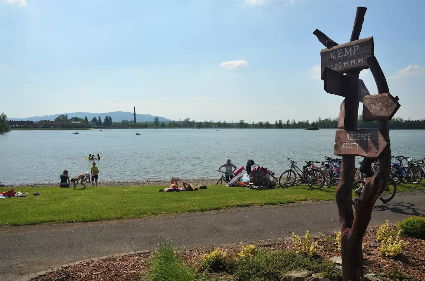 Lidé u jezera Baška s bicykly na kempu v přírodě.