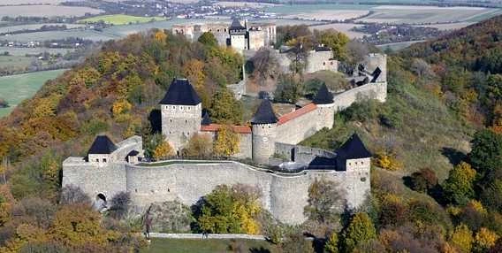 Zámek na kopci v Olomouckém kraji s podzimním lesím.