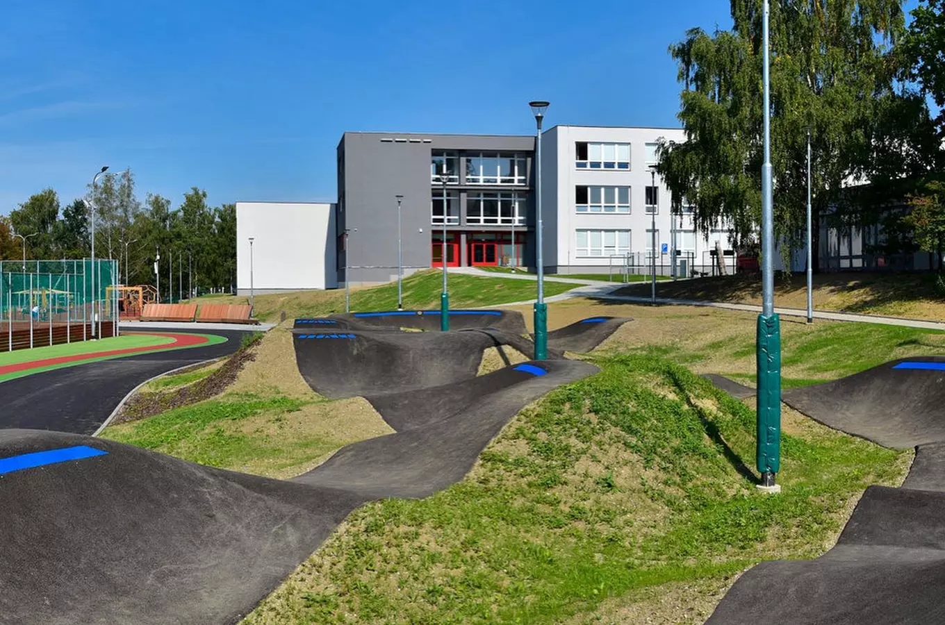 Modern inline bruslová stezka před školou na slunný den.