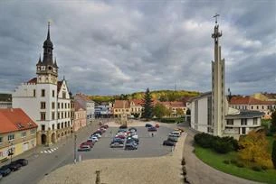Náměstí v Hustopečích s dvěma kostely a parkovacími místy.