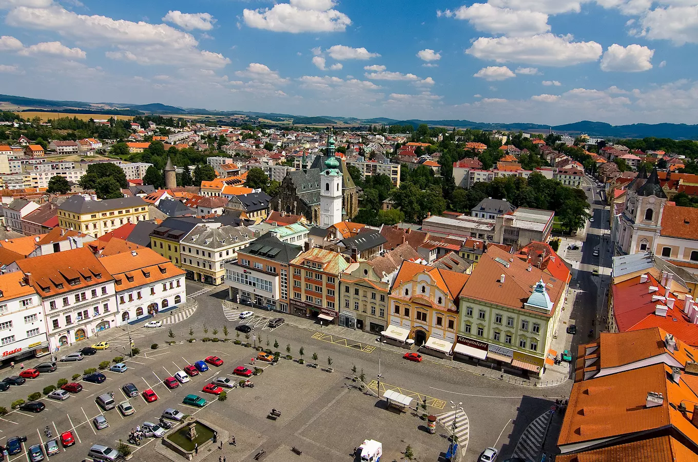 Pohled na náměstí v Klattovech s kostelem a barevnými domy.
