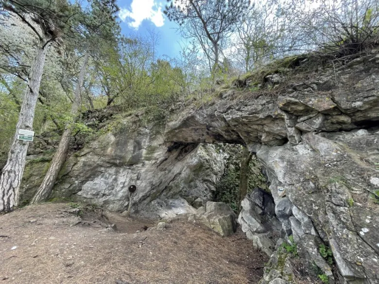 Přirozený skalní oblouk v lese na turistické trase