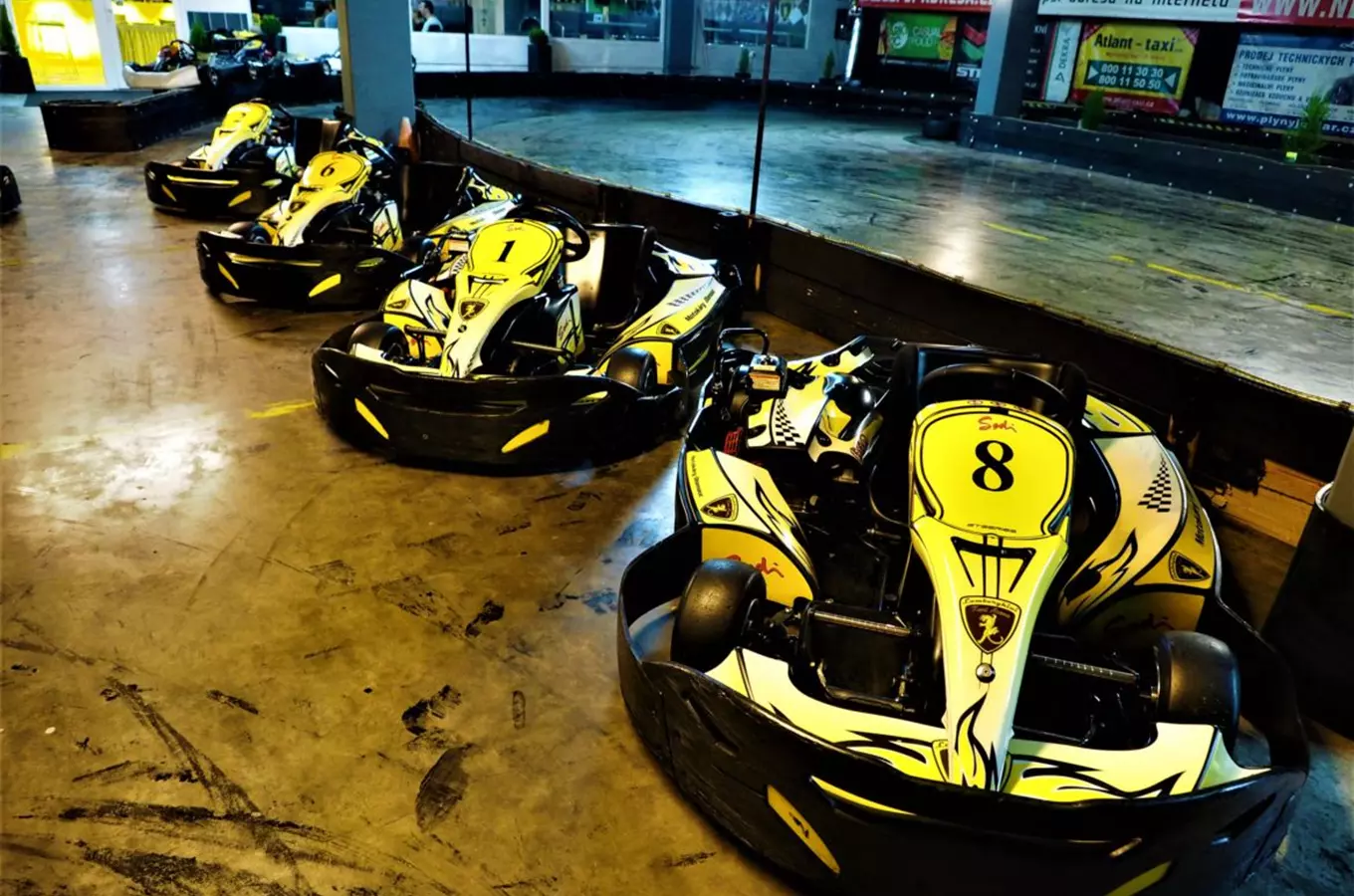 Vnitřní motokáry v areálu kartingu seřazené vedle sebe.