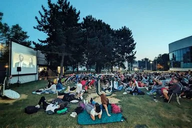 Venkovní promítání filmu s diváky na trávě v Ostravě.