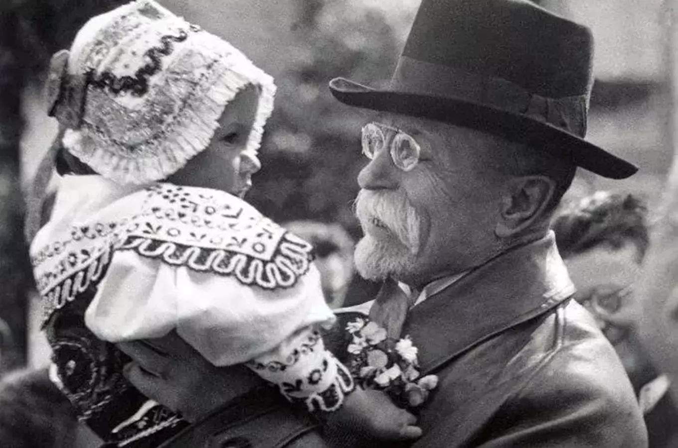 Tomáš Garrigue Masaryk drží dítě v tradičním oblečení.