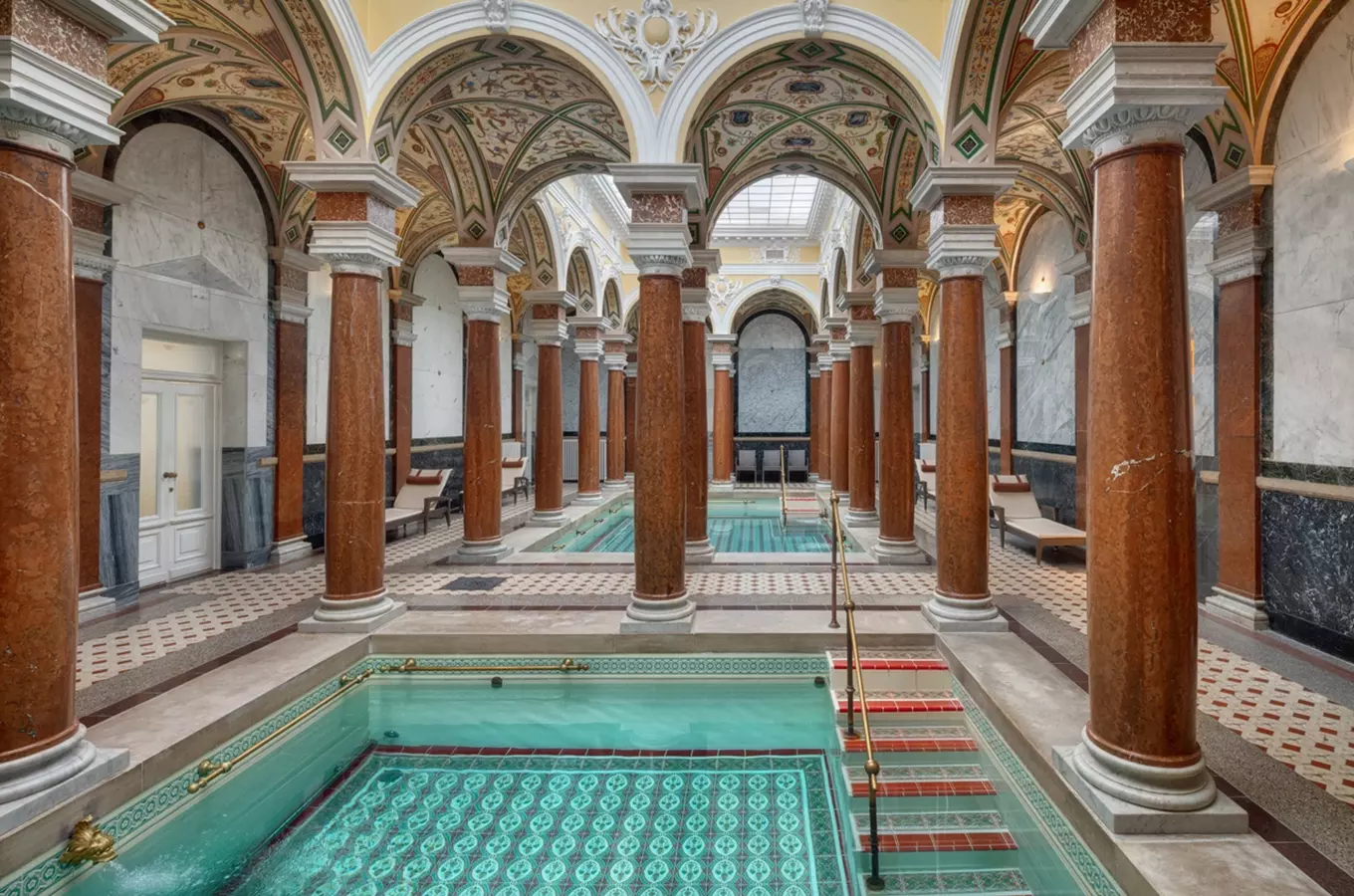 Historický bazén v lázních s architekturou a sloupky.