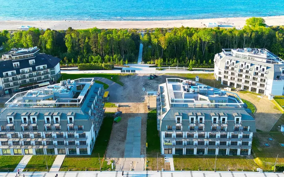 Moderní budovy u pobřeží Baltského moře v Polsku s pláží.