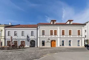 Historické budovy na náměstí v Otrokovicích pod modrou oblohou.