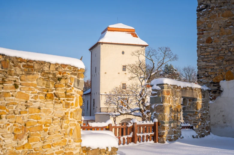 Zasněžený středověký hrad ve Frýdku-Místku pod modrou oblohou.