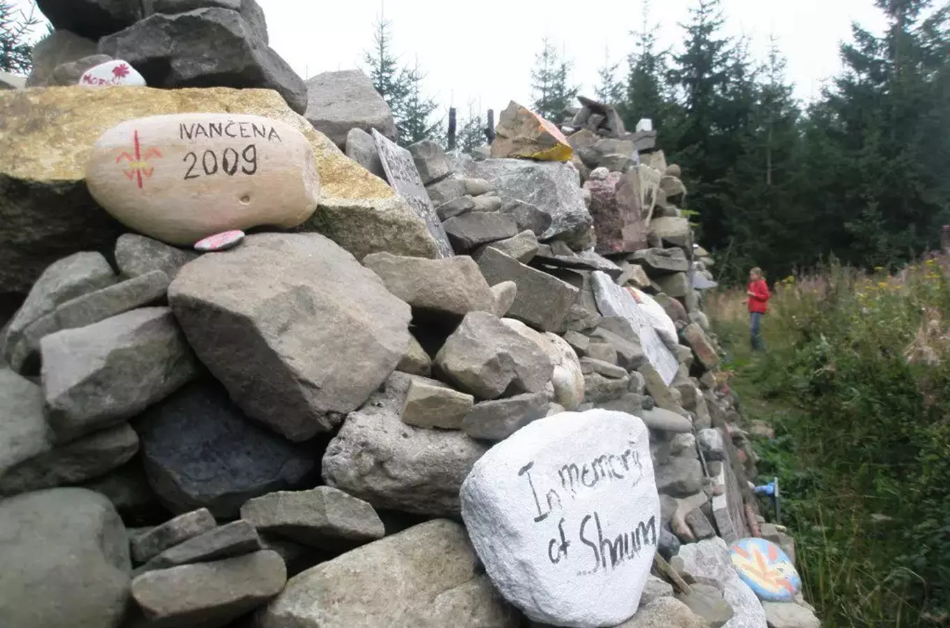 Kamenná hromada s nápisy připomínajícími jména a roky.