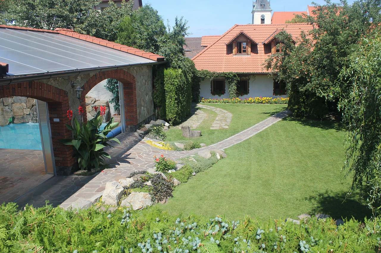 Zahrada s bazénem u domu v jižních Čechách.
