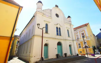 Historická kostel v Břeclavi na slunečním náměstí s barevnými domy.