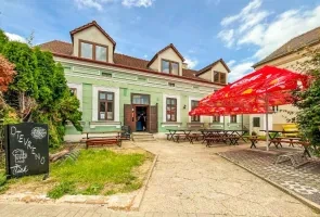 Historická budova s venkovním posezením ve Znojmě nebo okolí.