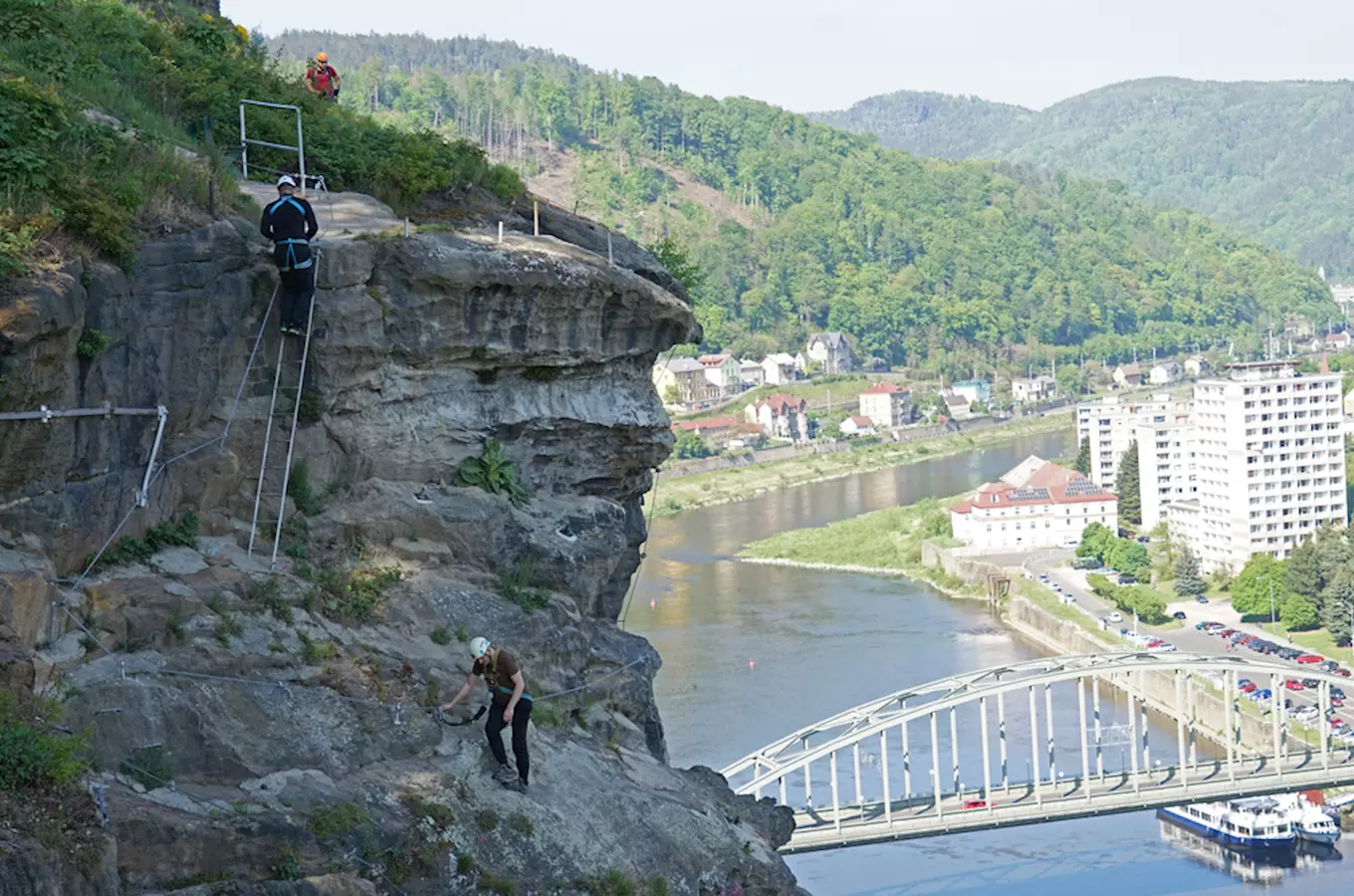 Turisté spouští z útesu nad řekou Labe v Děčíně.