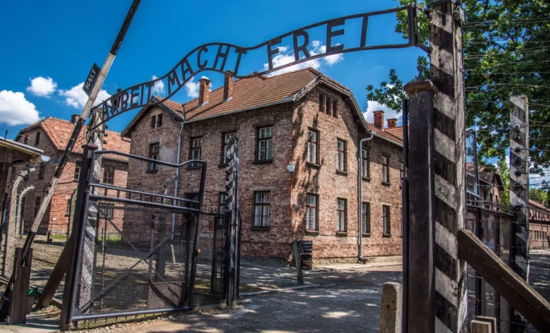 Vstupní brána koncentračního tábora v Osvětimi s nápisem Arbeit Macht Frei.